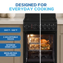 Black electric range with oven door open, interior light on, and cookies baking inside